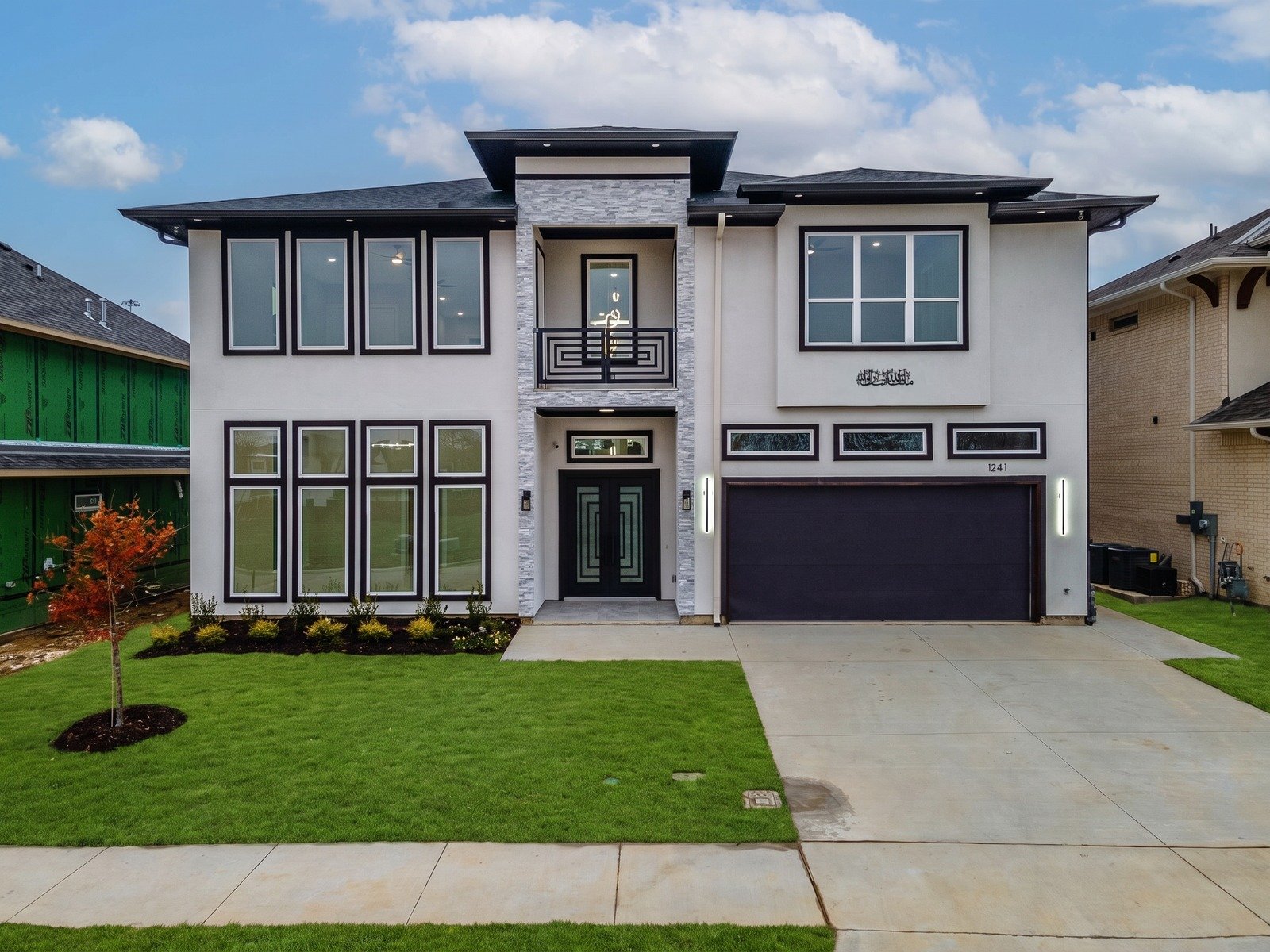 Completed Hamra custom home with tall windows and a stone entry